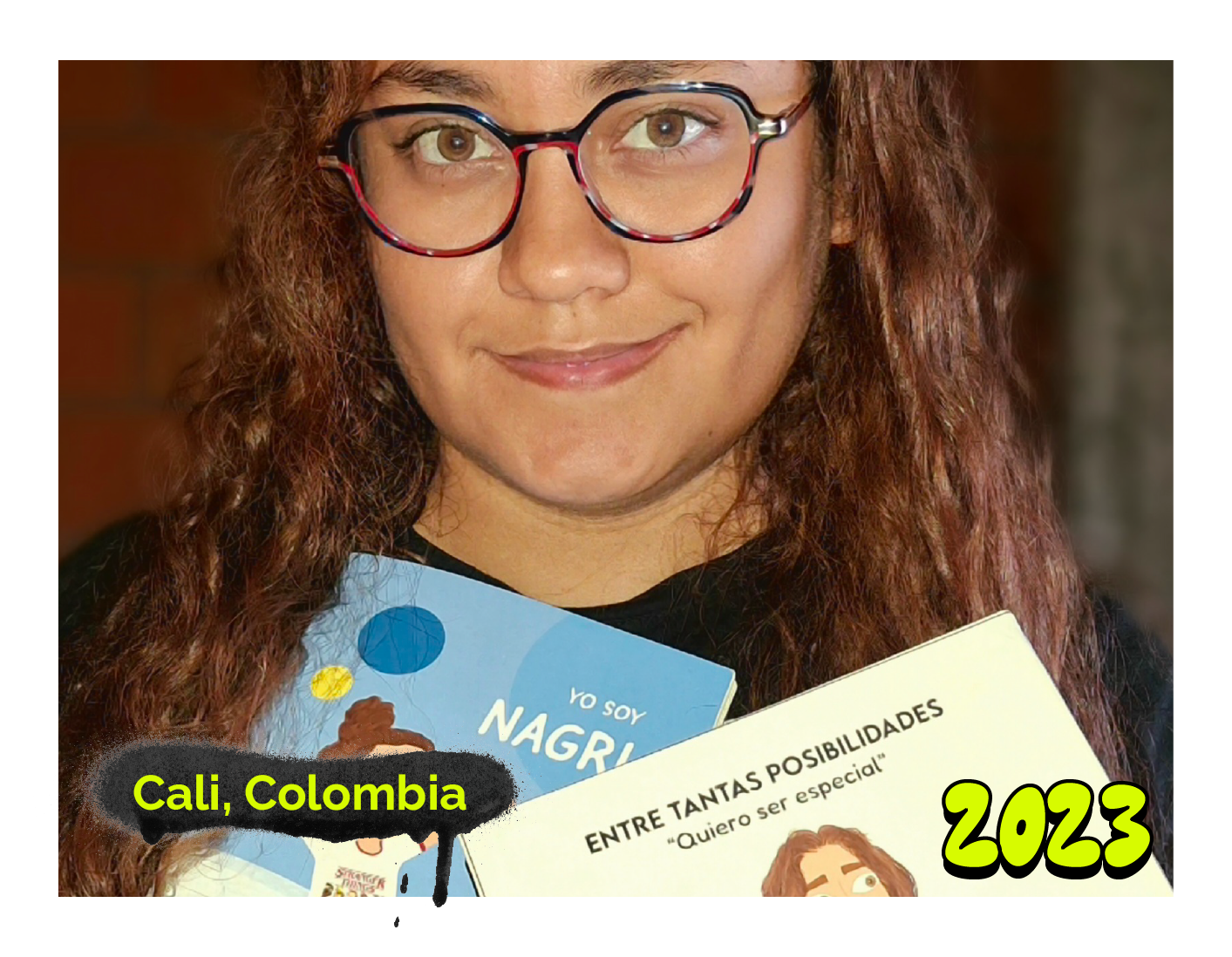 Fotografía de mujer joven con gafas, cabello largo y sonriente, sosteniendo los libros 'Yo soy Nagri' e 'Entre tantas posibilidades: Quiero ser especial'. En la esquina inferior izquierda dice 'Cali, Colombia', y en la derecha, '2020', ambos sobre fondo negro. La imagen tiene un marco blanco. En la parte inferior derecha tiene el año 2020